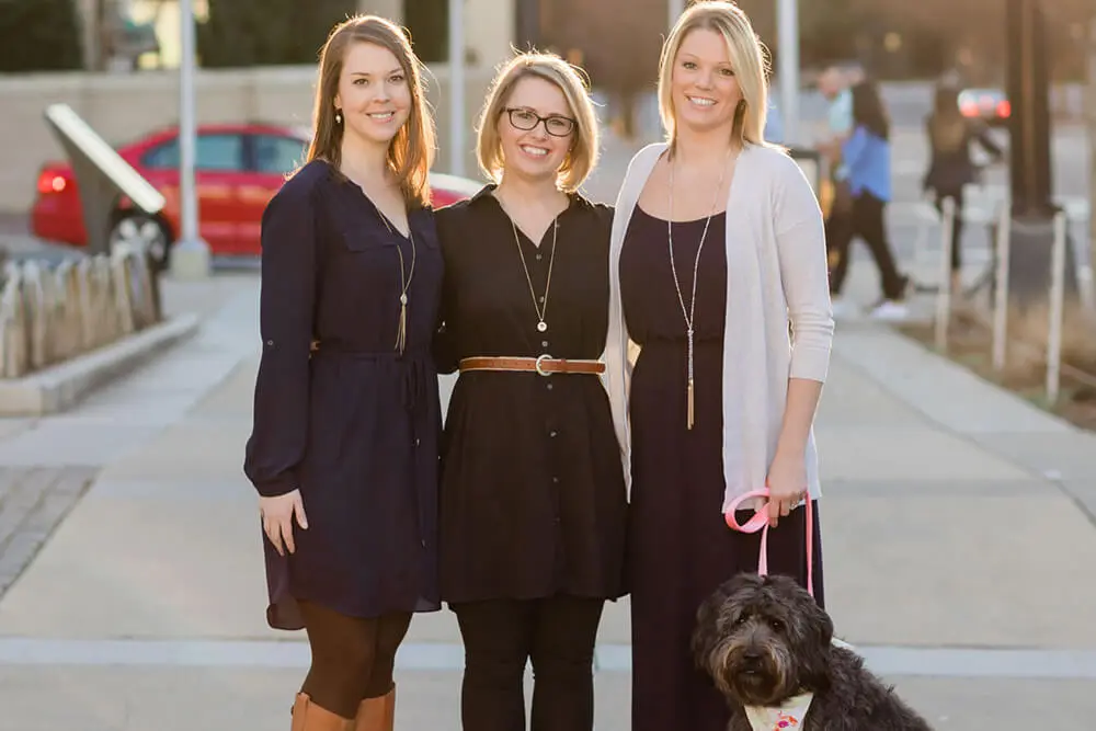 three therapists standing outdoors with dog